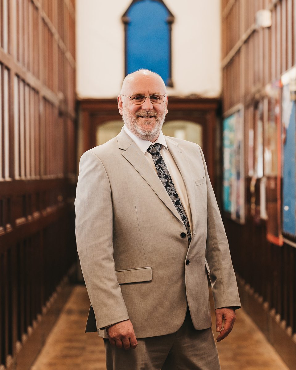 Paul Norton, Principal of Kings Monkton School and Chair of the Welsh Independent Schools Council, in a wood-panelled school corridor